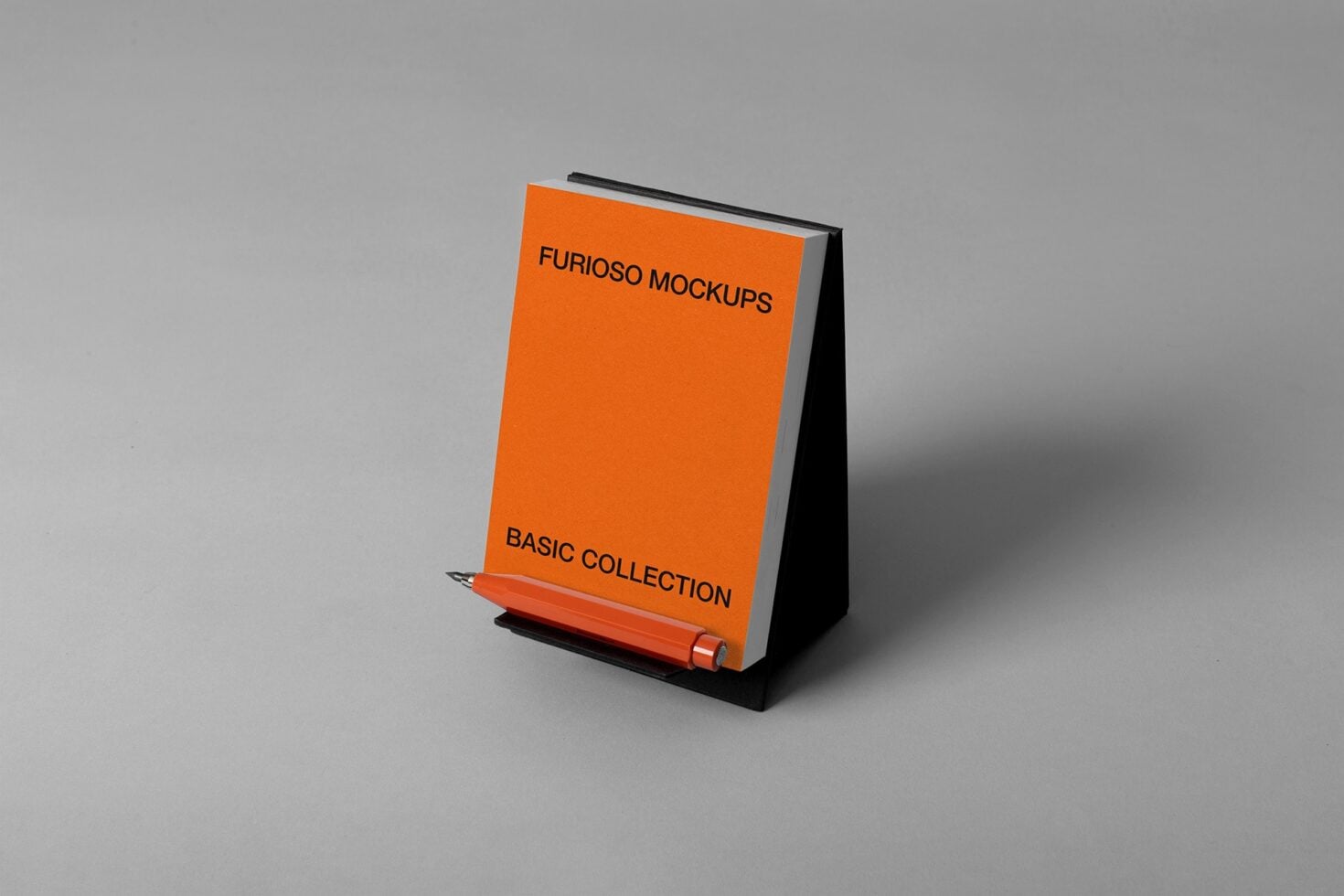 Desk tent style notepad mockup in orange with black stand, orange pen leaning against it