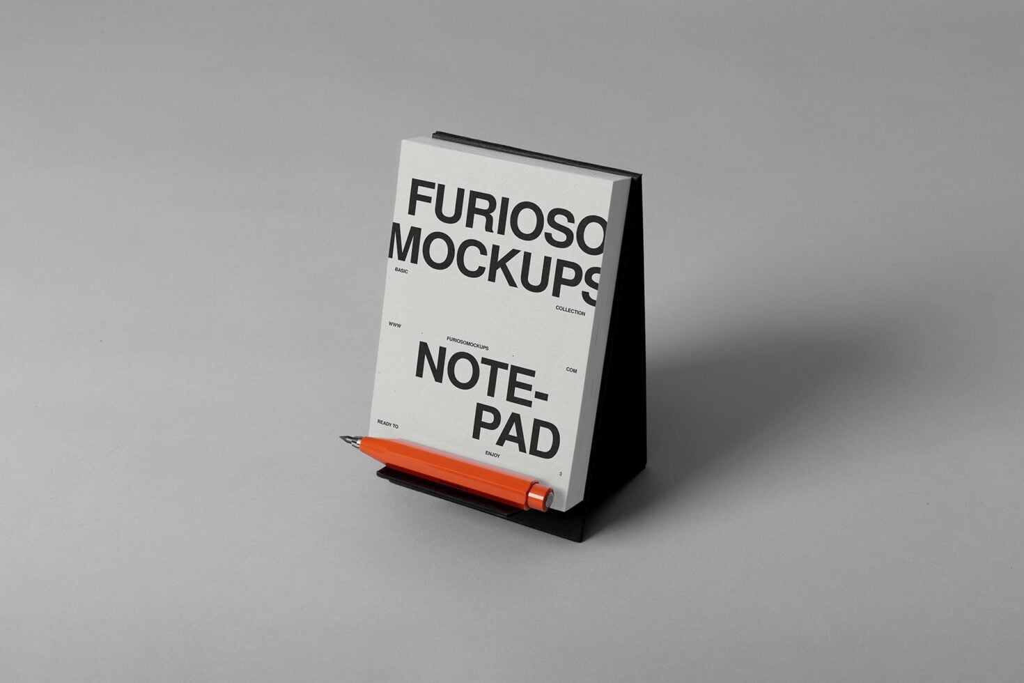 Tented notepad mockup on gray with orange pen alongside, cream cover with Furioso Mockups text