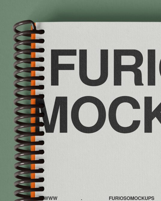 Spiral notebook mockup with orange binding against muted green background