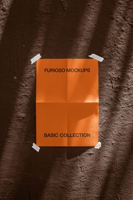 Orange poster taped to dark brick wall, white tape corners mockup