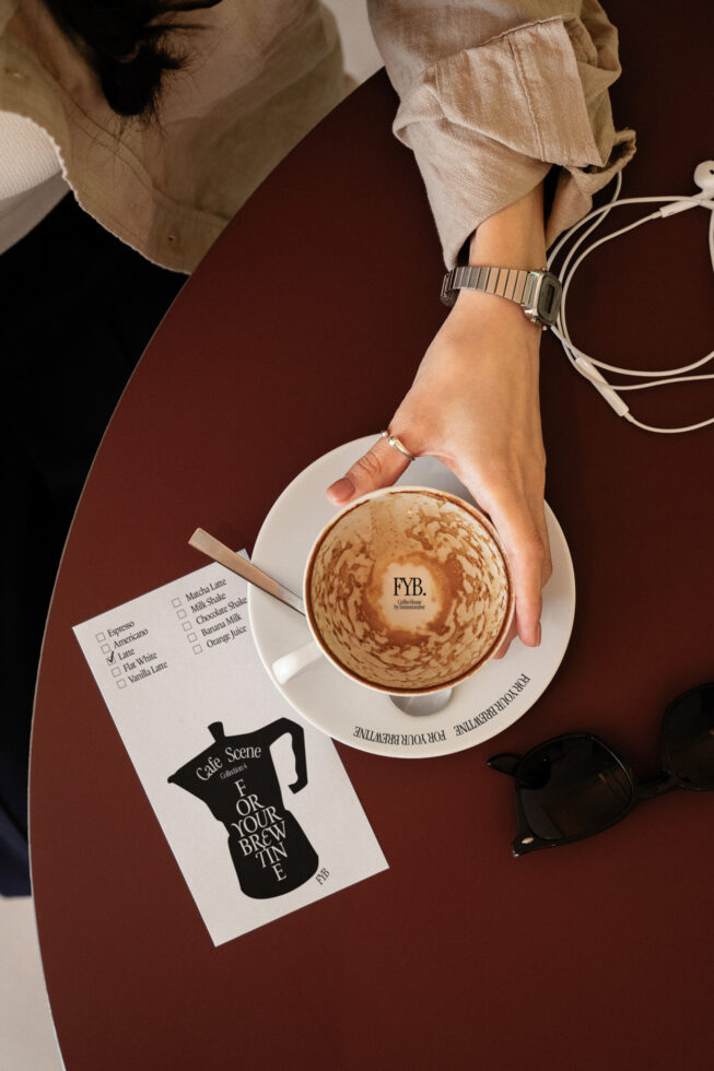 Coffee cup flat lay with white flyer mockup on burgundy background styled scene