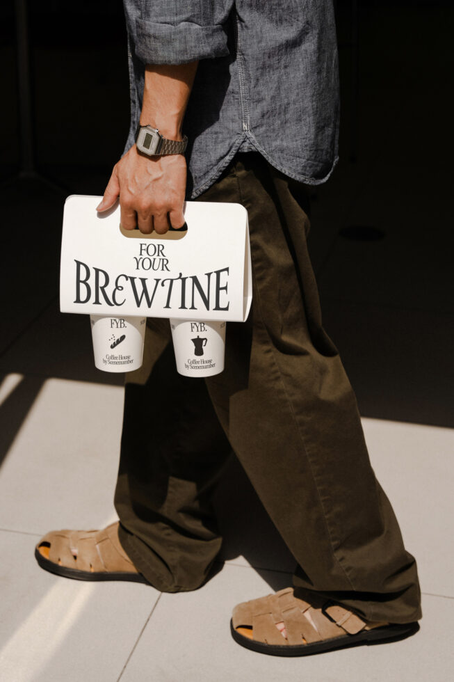 Man carrying white bag with two coffee cups mockup in casual denim style