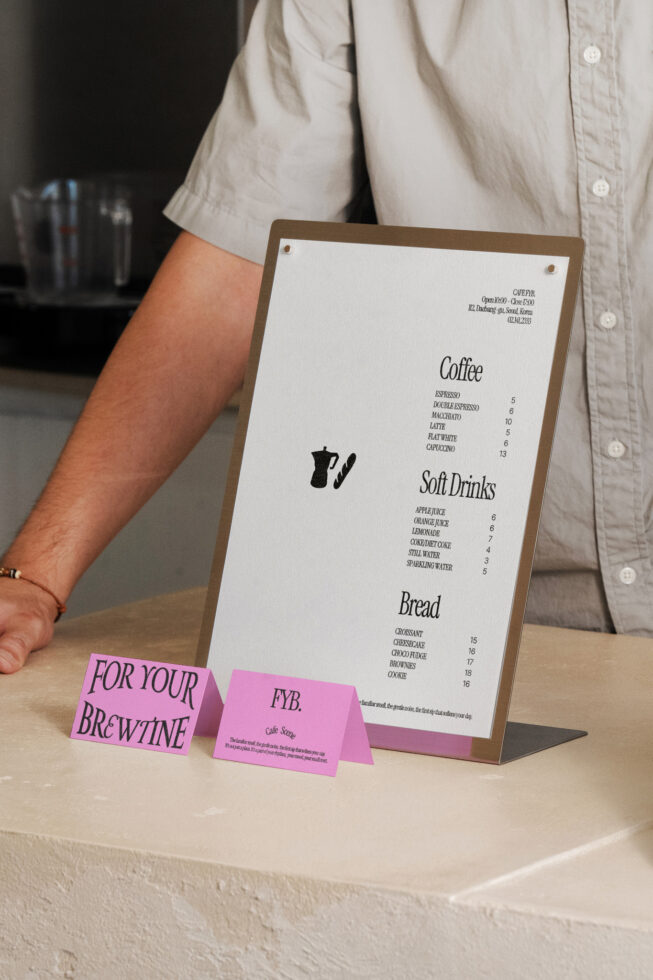 Wooden menu stand with bright pink table tent cards in front of it
