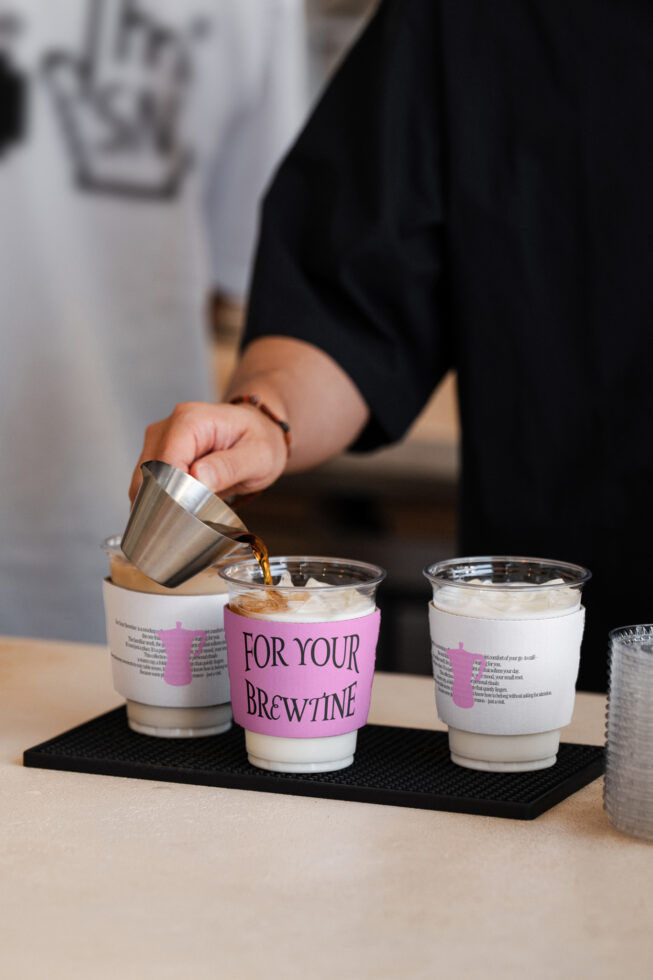Person pouring espresso into customizable coffee cup sleeve mockup