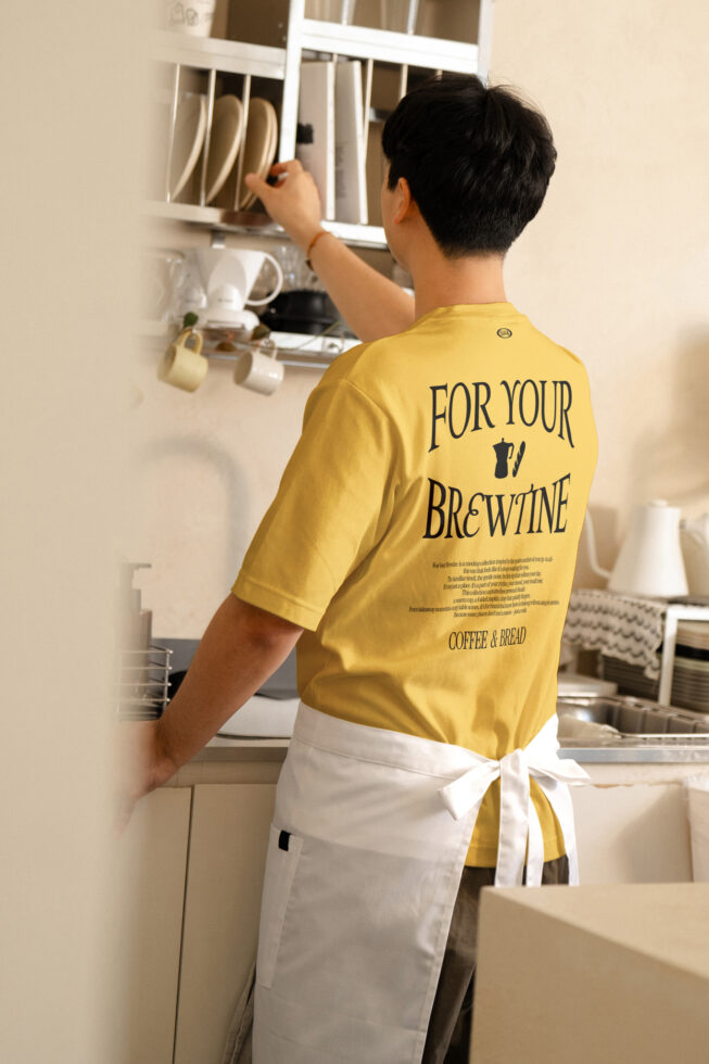 Yellow tee back print mockup worn in bright kitchen reaching up