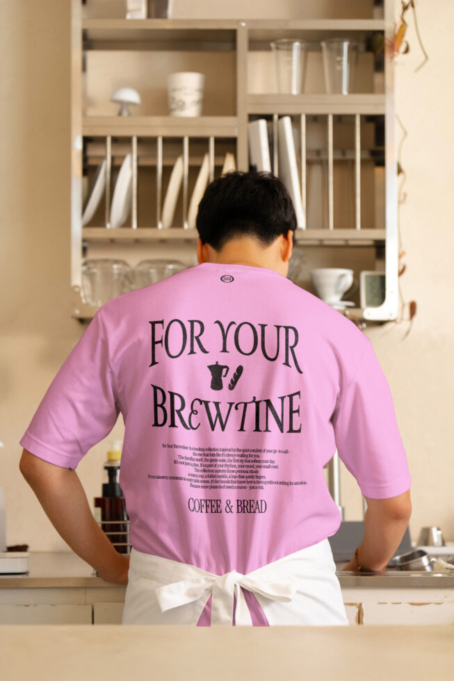 Pink t-shirt with For Your Brewtine back print in contemporary coffee shop setting