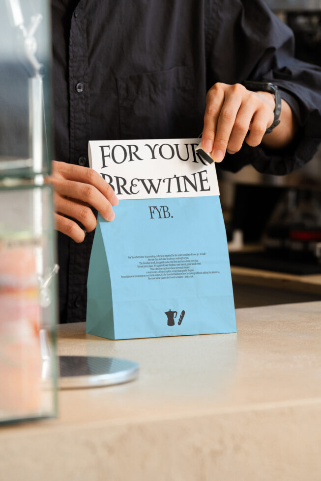 Light blue takeaway bag with For Your Brewtine heading being held open