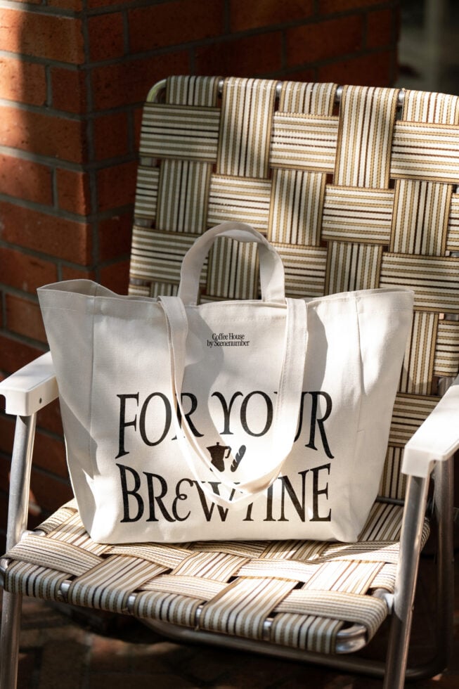 Cream tote with coffee house branding sits on woven patio chair