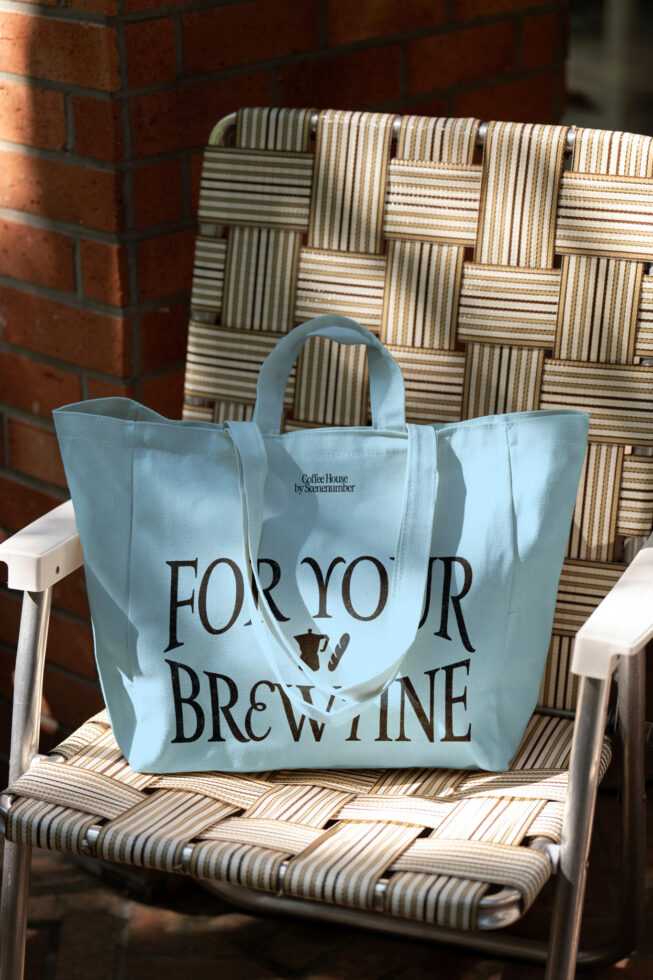 Light blue tote bag on striped chair with woven baskets in background