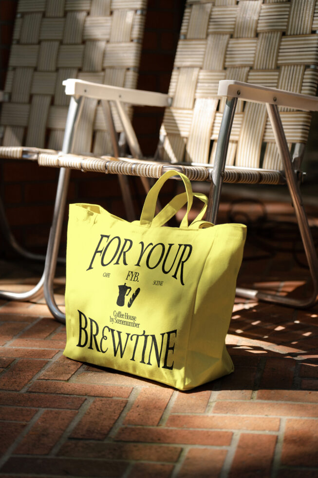 Vibrant yellow canvas tote bag positioned on brick patio near furniture