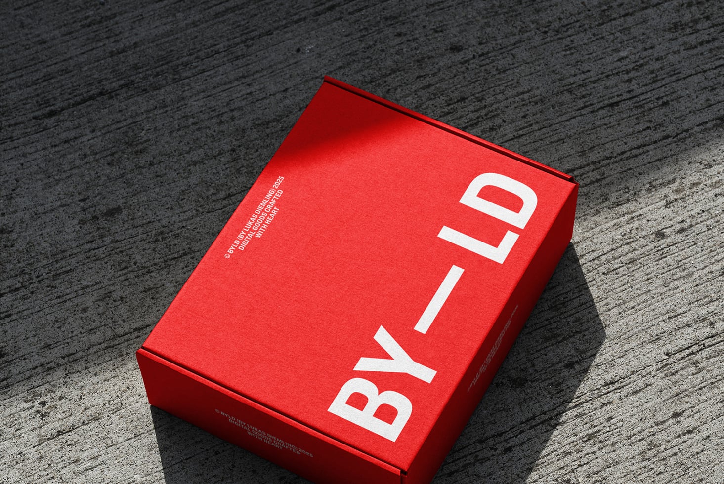 Bright red box with white BYILD text on concrete surface