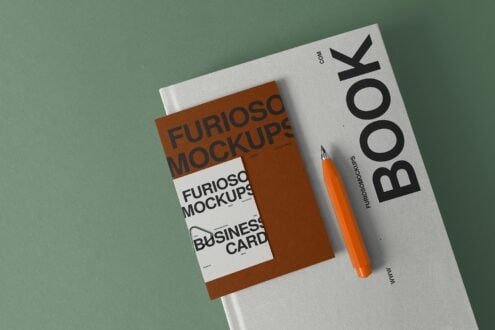 White book with brown business card mockup, orange pen on mint green surface