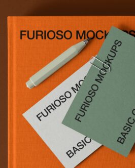 Orange book cover with cream marker pen on top, stacked cards below