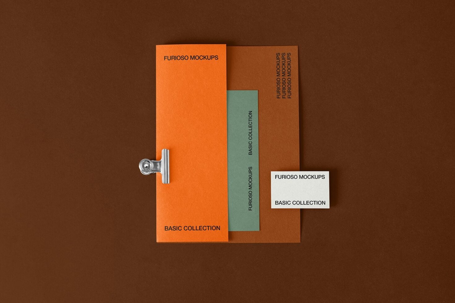 Stacked orange, rust, teal folders with metal clip on brown surface