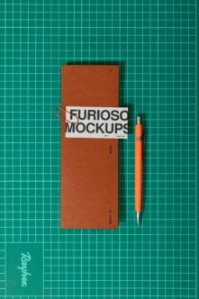 Rust folder with white label band, orange pen on teal gridded background