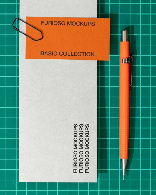 White envelope with orange band clipped, orange pen on teal grid backdrop