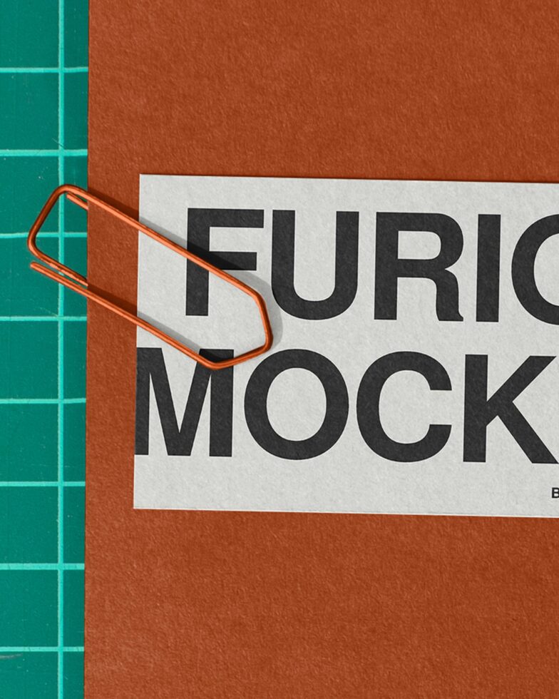 Orange clip holding white label over rust background with black serif type