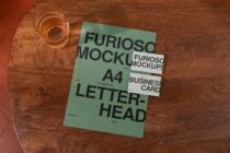 Green A4 letterhead with stacked business cards on wooden table mockup
