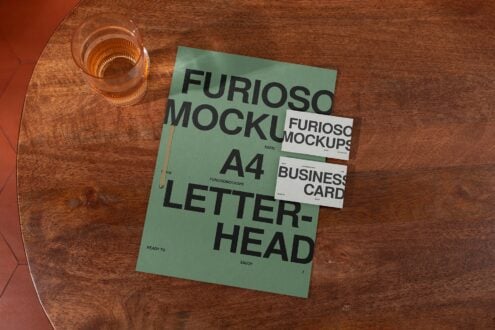 Green A4 letterhead with stacked business cards on wooden table mockup