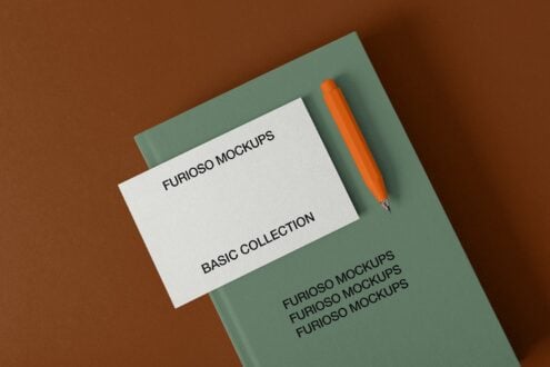 Sage green folder with white card, orange pen on brown background overhead shot