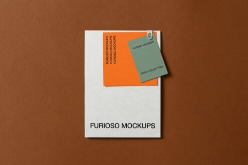 Business card mockup with green clip attached to orange card on white envelope