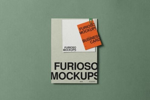 Layered stationery mockup showing orange business card with green paperclip on pale background