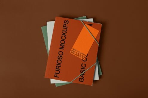 Four overlapping notebooks in orange, white, green displaying mockup layouts