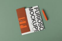 Folded business card mockup in rust orange with sans serif typography on sage green background