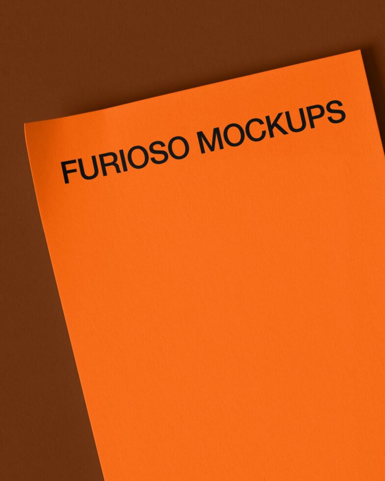 Bright orange flyer angled on brown background, black text top left