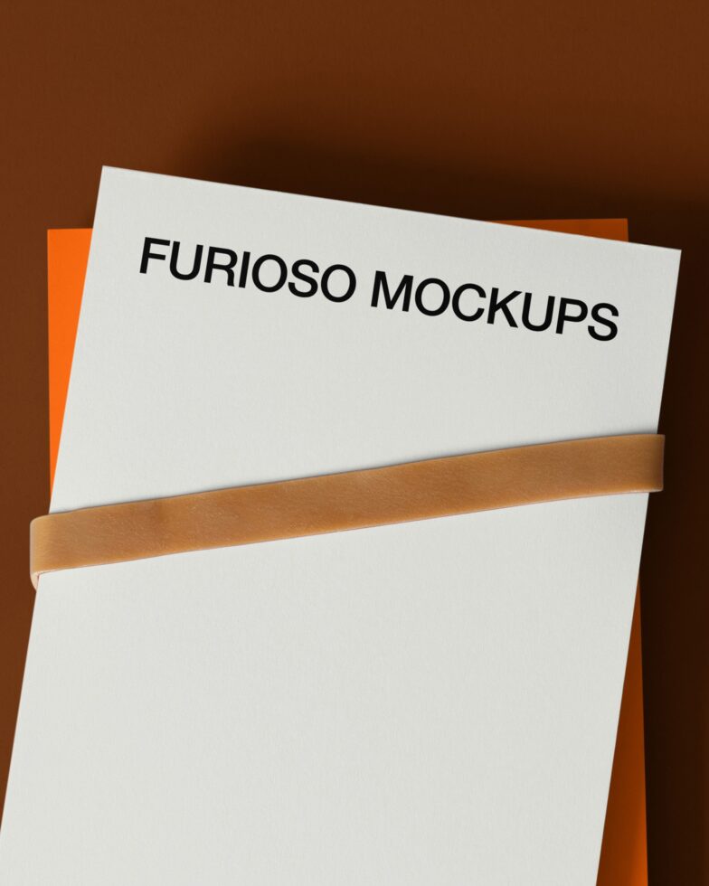 Stacked papers with tan band on brown background, top sheet text visible