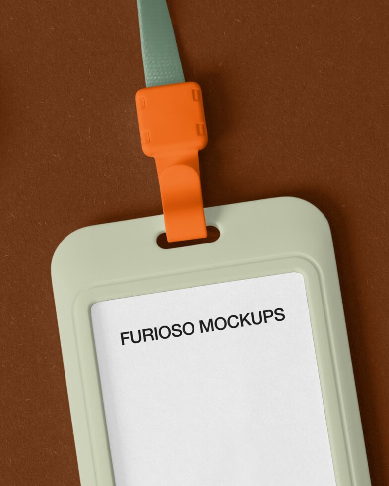 Cream ID badge with orange clip against brown background with mint lanyard
