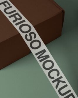 White branded tape with black text crossing brown box on sage green surface