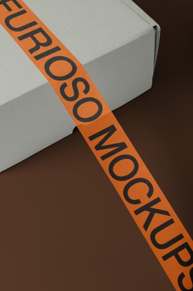 Orange branded tape with black text stretched diagonally across white box mockup