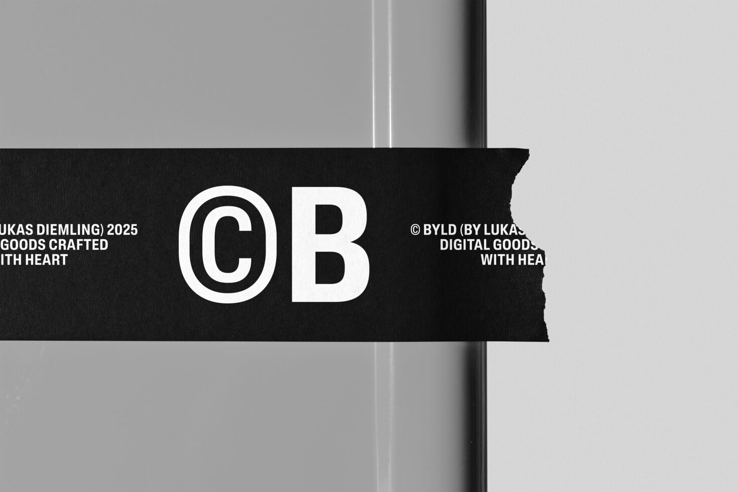 Black tape banner with white outlined GB letters against neutral background
