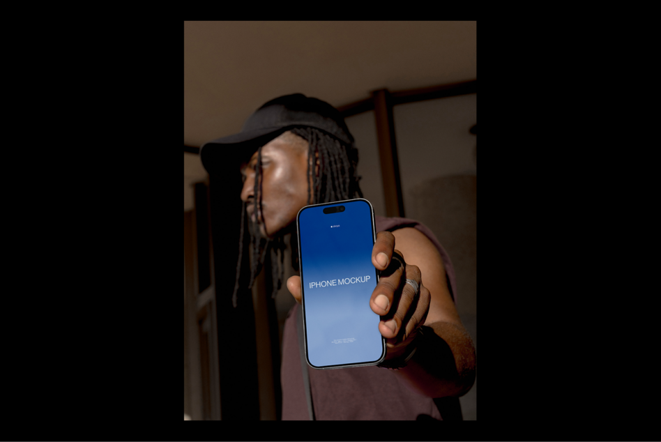 Modern iPhone mockup held by individual wearing cap in outdoor setting perfect for designers looking for realistic device templates in graphic projects
