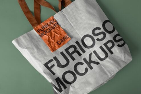 White canvas tote with brown handles, orange fabric label showing furoshiki care text