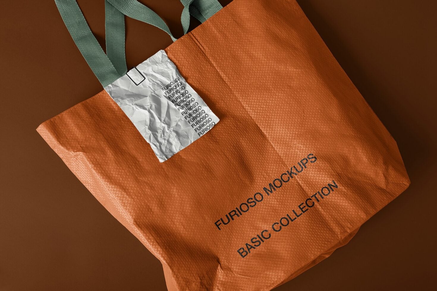 Orange textured tote with white wrinkled label, green handles at angled perspective