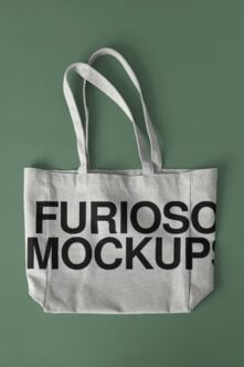 Cream linen tote bag with bold black sans serif text on soft green background