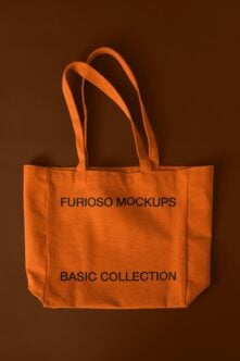 Bright orange canvas tote with dark text on brown background, thick rope handles