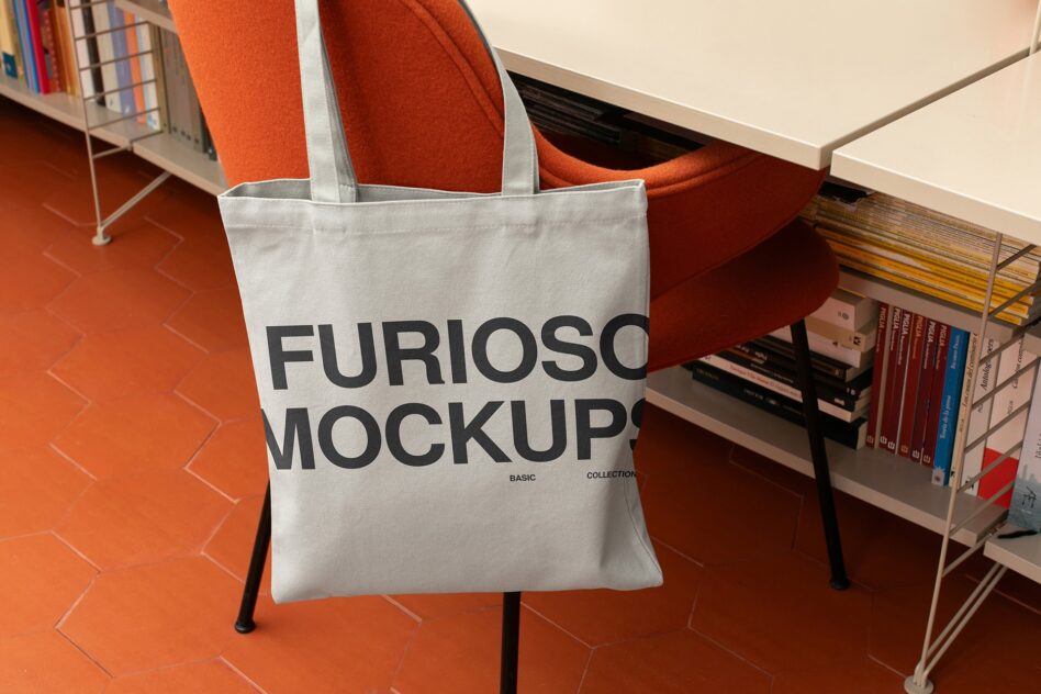 Cream cotton tote with black typography placed on mid century modern chair