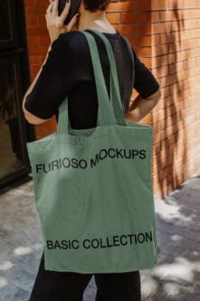 Person wearing green tote bag from behind on brick wall street
