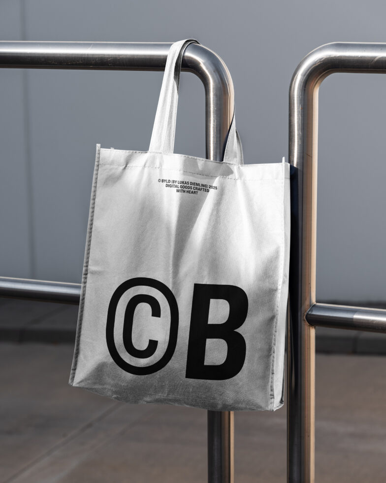 White tote bag with bold black CB initials hanging on chrome pipe