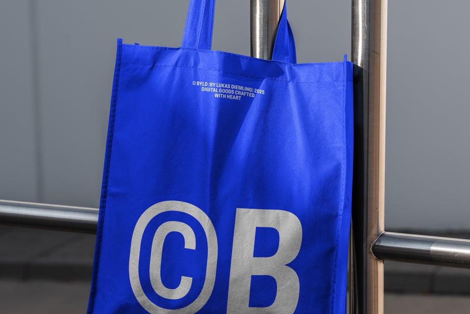 Royal blue tote showing large silver CB initials on metal rail