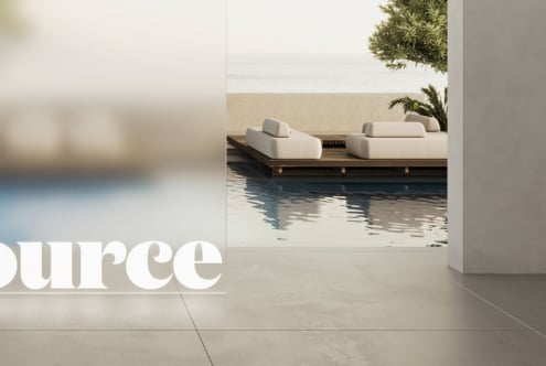 Partial white lettering visible from modern poolside lounge overlooking water view