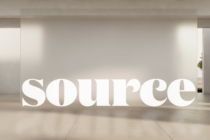 Sculptural white text displayed in clean minimal hallway with side lighting