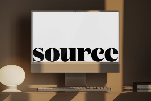 Monitor screen displaying bold serif text centered on white with minimalist desk setup below
