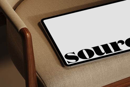 Tablet resting on beige chair arm displaying Source wordmark