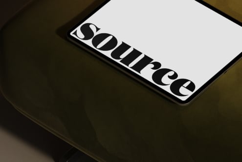Smartphone screen showing geometric logo design on white surface tilted view