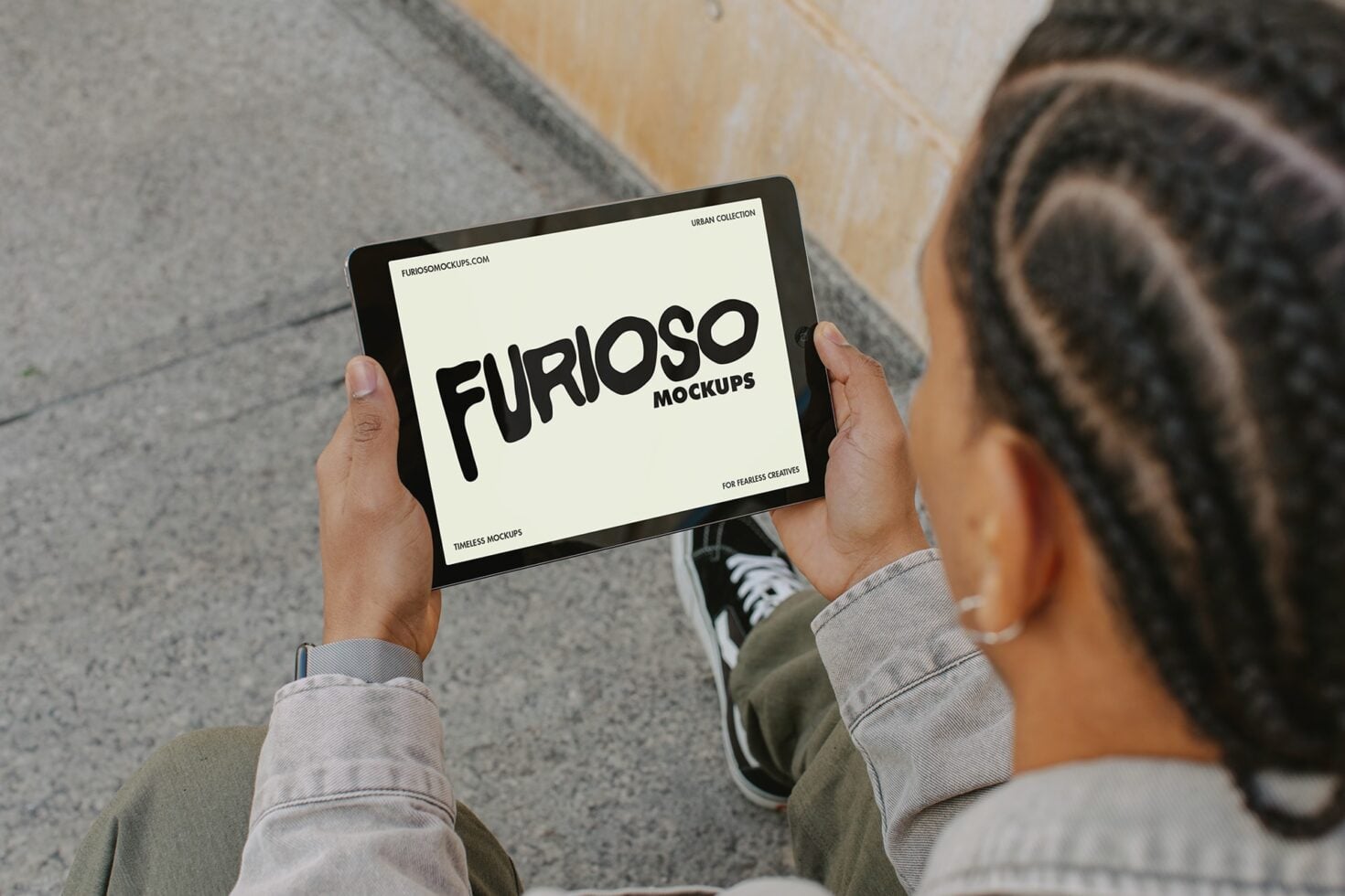 Person holding tablet with cream screen showing Furioso Mockups text logo