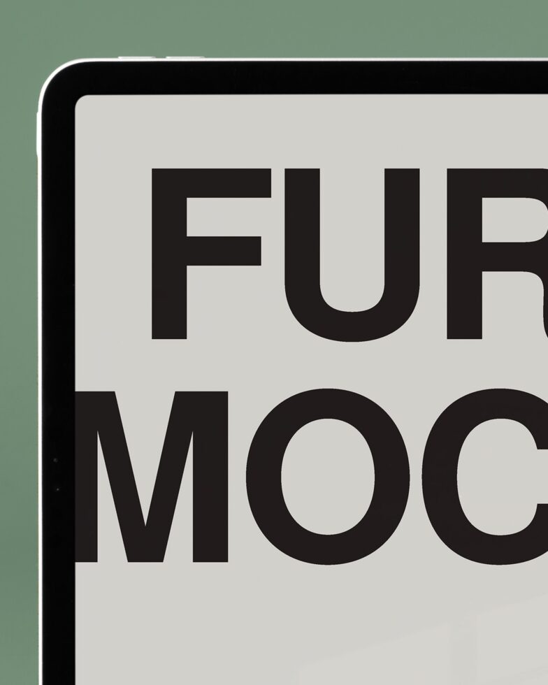 Tablet screen close-up showing large bold sans serif typography on green backdrop